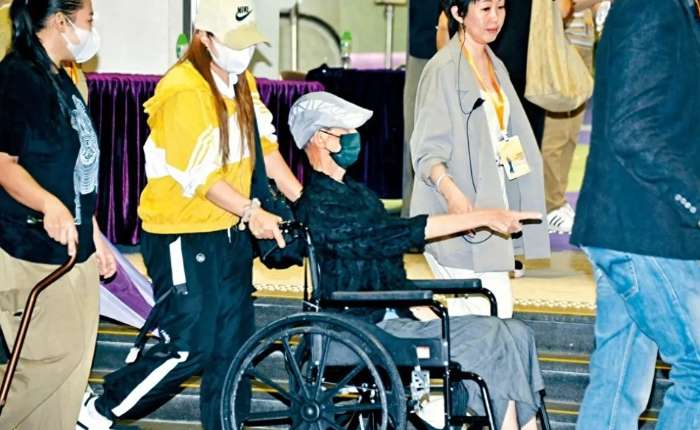 张达明坐着轮椅。