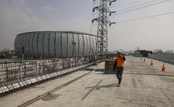 图为工人在雅加达丹戎不碌地区海港道二期高速公路项目施工现场行走。