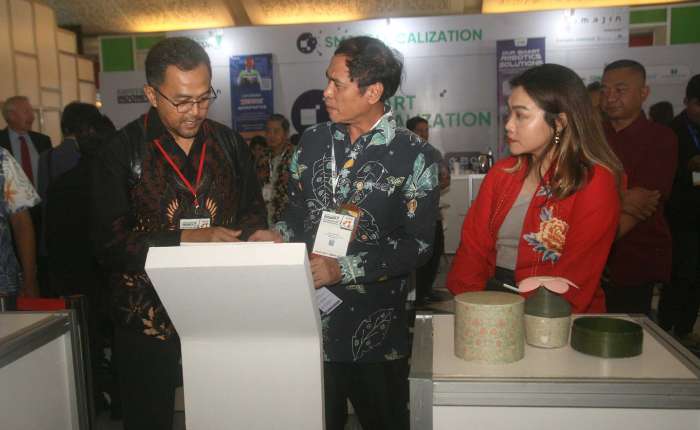 Pamerindo Indonesia公司项目总监Meysia Stephannie(右)，与工业部下游化学与制药工业司司长Sopar Halomoan Sirait(中)正在参观一个展台。(商报/Hermawan摄)