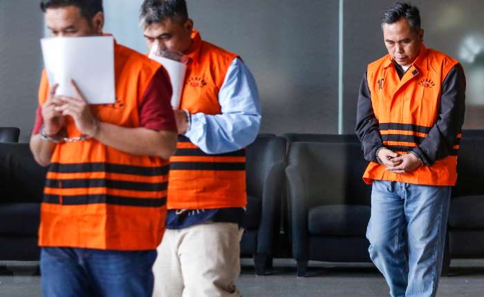 2026年1月11日，北雅加达中级税务局局长德维·布迪（中）与税务评估员阿斯柯布·巴赫蒂亚尔（左）、北区中级税务局稽查咨询科科长阿古斯·赛义夫丁（右）在雅加达肃贪委员会红白大厦接受问讯后穿着犯人背心。