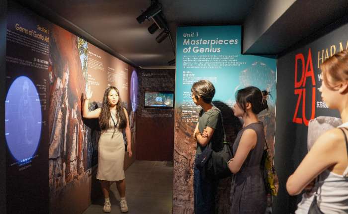 图为专业讲解员带领嘉宾深入了解展览内容。(中新社)