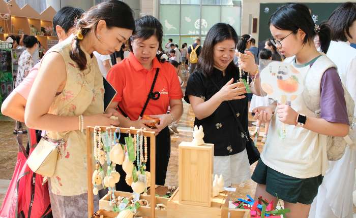 8月3日，民众在挑选竹文创周边。当日，“绿水青山20年——安吉‘竹’构精彩专题展”在浙江杭州启幕，展览设置“识竹、知竹、用竹、趣竹”四大展区，吸引游客参观。中新社记者曹丹摄  