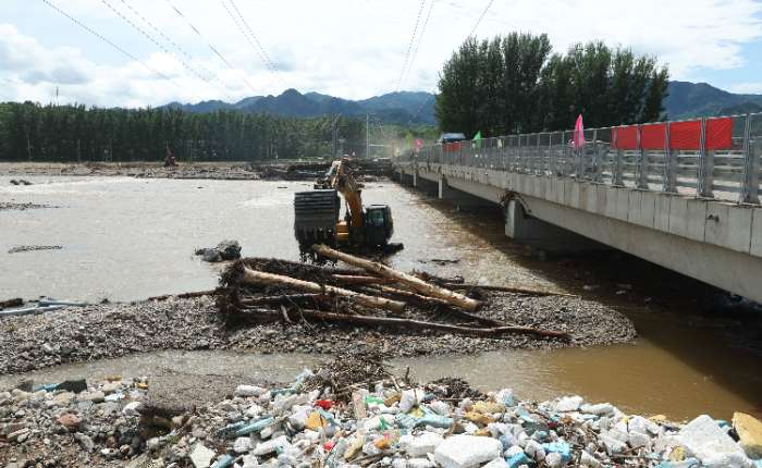 8月5日，在北京市密云区北庄镇清水河边，工作人员使用挖掘机疏浚河道。7月23日至29日，北京市遭遇极端强降雨，密云、怀柔、平谷、延庆等北部山区突发山洪，造成重大人员伤亡和财产损失。 中新社记者 蒋启明 摄  
