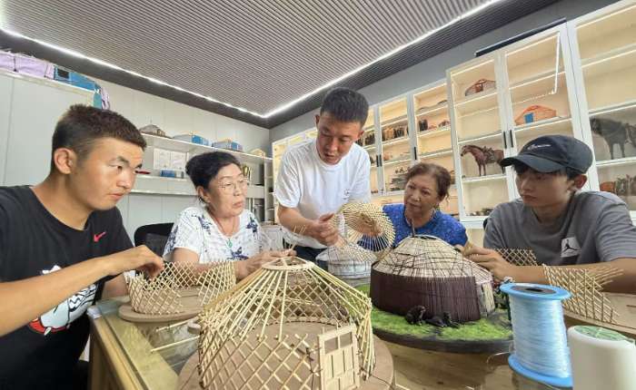 7月13日，内蒙古呼伦贝尔，年轻的蒙古包营造技艺传承人正在教授学生们如何搭建蒙古包。 中新社记者  张玮 摄