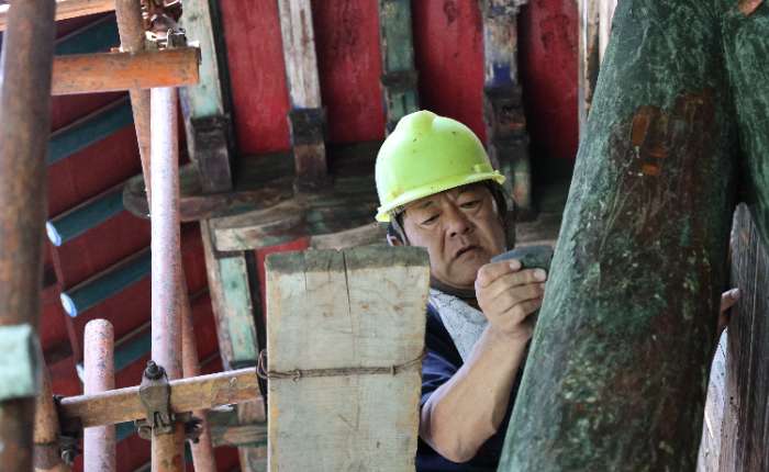 8月5日，三孔古建队的文物修复师在周公庙清理破损地仗。中新社记者 赵晓 摄