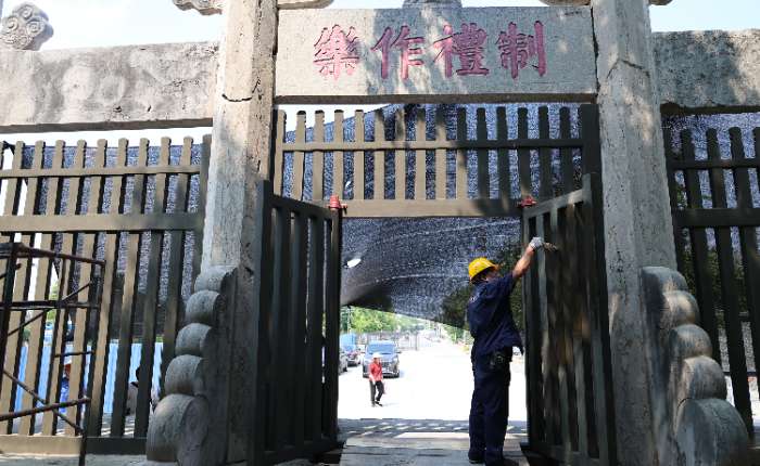 8月5日，三孔古建队的文物修复师为制礼作乐坊格栅门涂刷油料。中新社记者 赵晓 摄