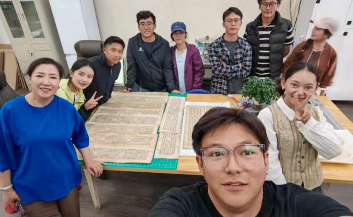 2025年7月9日，达珍（左一）在西藏大学古籍修复室为2024级中国古典文献学（藏）学硕士研究生指导古籍修复。（受访者供图）