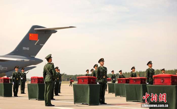 图为礼兵将殓放志愿军烈士遗骸的棺椁从专机上护送至棺椁准备区。
