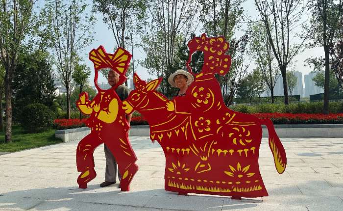 9月12日，民众在山西省太原市迎泽大街月老广场的雕塑前合影留念。 中新社记者 李庭耀 摄