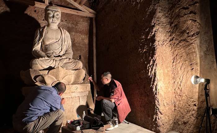 9月2日，麦积山石窟第133窟内，牟常有（左）和徒弟李浩亮（右）正在进行修复工作。中新社记者  丁思  摄