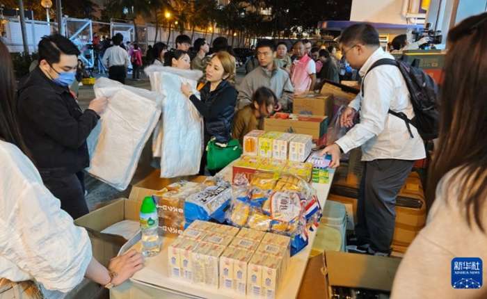 11月26日，受火灾影响的居民在跨部门援助站领取救援物资。新华社