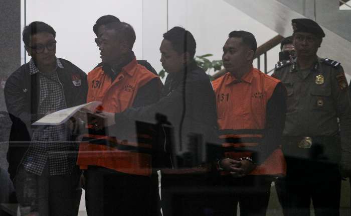 2026年4月12日凌晨，印尼图隆阿贡县县长加图特（左二）及其副官德维（右二）在雅加达肃贪委员会红白大楼内接受完一场现场抓捕行动后的审查，身着囚服背心。肃贪委员会在此次行动中确定并拘留了两名嫌疑人，即加图特及其副官德维·约加·安巴尔，同时查获了价值3.354亿盾的现金证据。