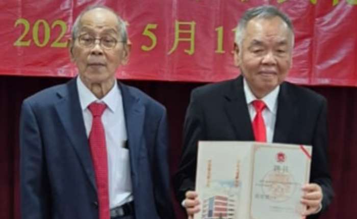 兴安会馆永久荣誉会长关文龙（左）向新任会长黄宥铭颁发聘书
