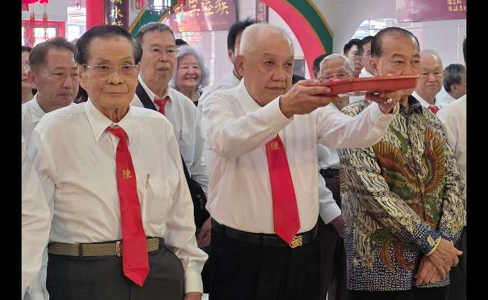 4.	陈炎松（中）敬献花果。