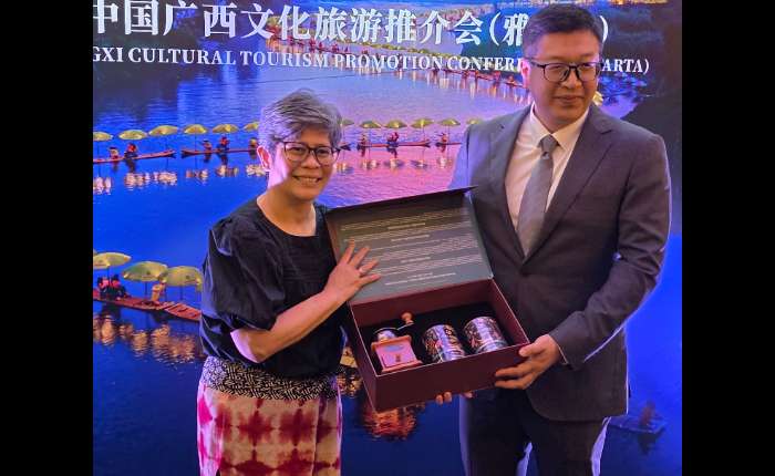 广西壮族自治区人民政府新闻办主任黎攀赠送（右）赠送赠送纪念品给印尼旅游部东亚、澳大利亚及大洋洲国际旅游市场推广司司长Yulia女士