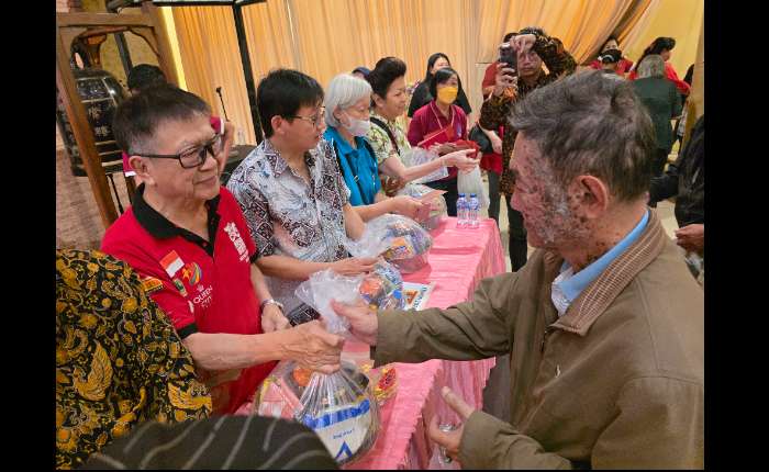 杉振法师代表慧雄大和尚把爱心礼篮移交给贫民