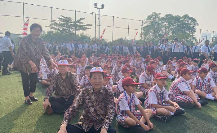 仪式结束徐胜文辅导委员伉俪和梁伟强校友与小学生们合影